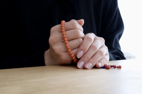 数珠を持った女性の手