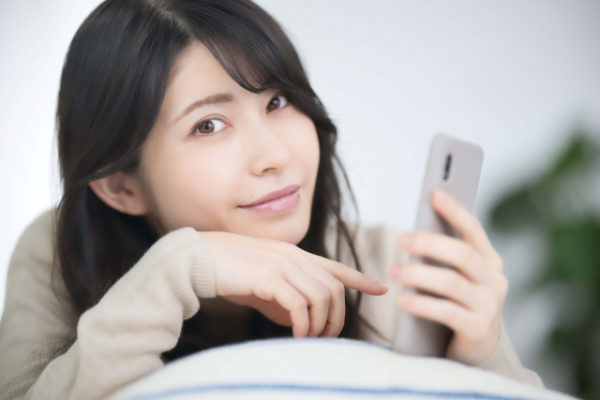 スマホの変身を確認する女性